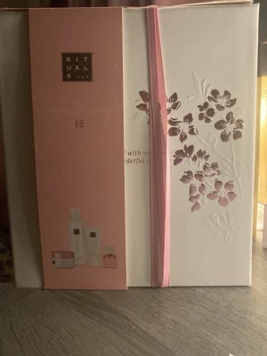 Rituals The Ritual of Sakura presentbox - Lyxig presentbox från Rituals i serien The Ritual of Sakura. Vit låda med rosa detaljer och blommönster i relief. Innehåller flera hudvårdsprodukter i mindre storlekar och en parfym, perfekt för dig som vill testa serien eller ge bort som gåva. 
