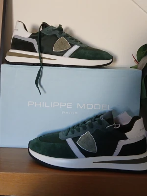 Philippe Model skor - Stilrena sneakers från Philippe Model i mörkgrönt mocka och mesh med vita och svarta detaljer. Skorna är äkta o kostar 2500kr nypris, skickat är lite sämre än på bilden därför säljer jag billigt, hör av er vid frågor🙌 Öppen för byte av andra skor!