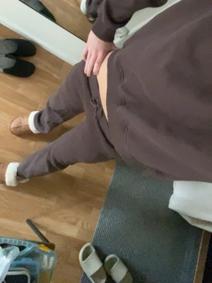 Lågmidjade Bruna mjukisbyxor med tröja till   - Mysiga bruna låga mjukisbyxor och mysig brun tröja (mjukisett).  Perfekta för chill eller hemmadagar. Tillverkade i mjukt material som känns skönt mot huden. Xs i byxorna s i tröjan. 