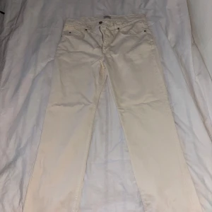 Beiga raka jeans - Säljer ett par beiga jeans med rak passform och klassisk femficksdesign. Jeansen har bälteshällor och knappgylf. Perfekta för dig som vill ha en clean och enkel look till vardags. Materialet känns som bomull med lite stretch. Passar 32/32 också 31/32. Köpta på Åhléns endast provade, lappar avtagna 