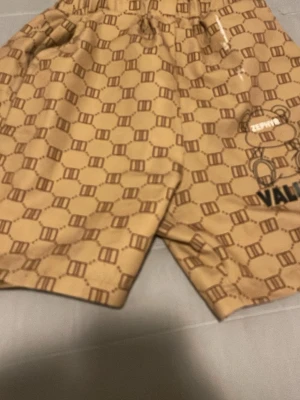 Beige mönstrade shorts från Zephy - Säljer ett par beige shorts från Zephy med all-over tryckt mönster i brunt och svart. Shortsen har elastisk midja och sidofickor. Perfekta för dig som gillar streetwear och vill sticka ut lite extra.