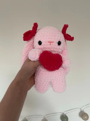 Virkad rosa kanin med hjärta - Supersöt handvirkad rosa kanin som håller i ett rött hjärta! Funkar bra som både gosedjur och rumdekoration!