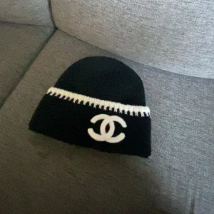 CC Beanie - Fet svart Mössa crossad med vita detaljer som står ut. denna produkt är för dig som vill vara lite lowkey men står ut samtidigt.                        Oanvänd!!!
