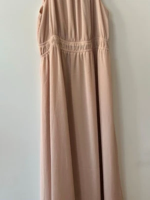 Beige långklän enter i luftig bomull - S late en beige plain långklänning i luftig, mjuk bomull. sopassning med avslappnad im dip och lätt rynkade detaljer vid midjan. Perfekt för varma dagar och enkel att styla med access’t sop. Storlek M/L. 