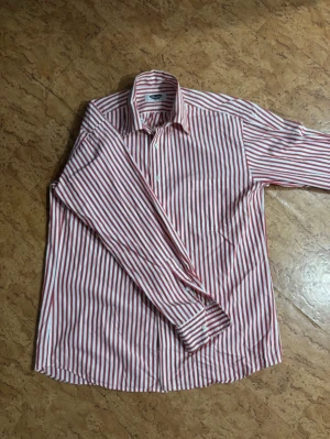 Stenströms skjorta  - Snygg vintage skjorta från Stenströms med rödvita vertikala ränder och klassisk krage. Skjortan har långa ärmar med manschett och vita knappar framtill. Tillverkad i mjuk bomull som känns skön mot huden. Perfekt för dig som gillar stilrena och färgstarka plagg.