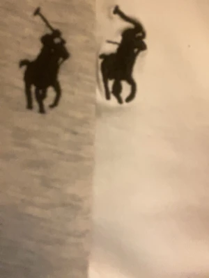 Säljer en polo väst - Två klassiska t-shirts från Polo Ralph Lauren, en i grått och en i vitt, båda med den ikoniska svarta polospelaren broderad på bröstet. Perfekta basplagg med normal passform och mjukt bomullsmaterial.