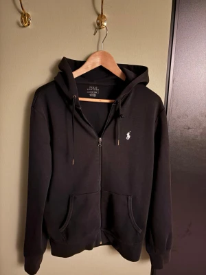 Svart raulph Lauren hoodie - Behövs nog inte förklara mycket. Passar till alla casual tillfällen bättre än väl. Skick 8/10