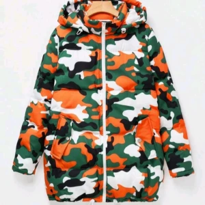 HELT NY & OANVÄND cool camouflage jacka / vinterjacka, Strlk: Medium - HELT NY & OANVÄND cool camouflage jacka / vinterjacka, Strlk: Medium/38-40. Vit/grön/orange. Vadderad och varm med fickor och luva. Fickorna stängs med lock och har tryckknapp på varje. Har pytteliten defekt framtill i form av blå liten prick från bläckpenna, syns knappt - se bilder, tex sista bilden.