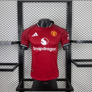 Manchester United matchtröja röd - Snygg röd Manchester United matchtröja från Adidas med klubbmärke på bröstet och vita detaljer. Tröjan har korta ärmar, rund hals och svart/vita ränder på axlarna. Materialet är lätt och andas, perfekt för fotboll eller träning.
