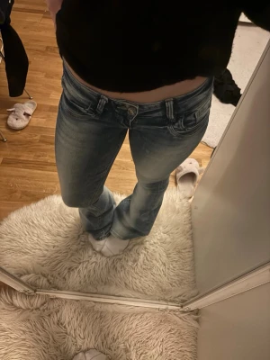 Blå bootcut jeans med slitningar - Säljer ett par blå bootcut jeans good fit med snygga slitningar och tvättade detaljer. Jeansen har låg midja, med stretchiga material. Inte alls mycket använda och i Storlek S och passar nästan perfekt i längden på mig som är 160cm☺️🌸