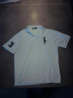 Ralph Lauren Pike - Säljer en riktigt stilig piké från Ralph Lauren i färgen Ljus blå, man ser inte riktigt att den är ljusblå i bilden men det är den. Storlek: L. Skriv vid frågor eller kom med bud!