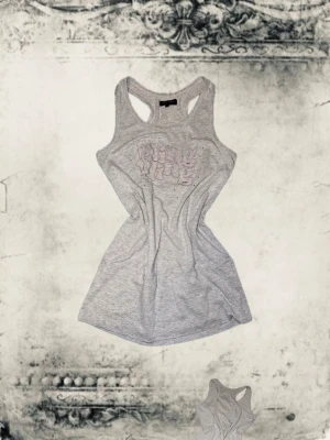 Grå linnetopp från bikbok - Snygg grå linnetopp från bikbok med broderad logga framtill i ljusrosa. Modellen är ärmlös med klassisk racerback och mjukt bomullsmaterial som känns skönt mot huden. Perfekt att styla med jeans eller shorts för en avslappnad look. Stor storlek L men passar storlek M! 