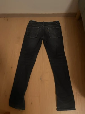 Levi’s 512 slim fit  - W28 L29 Snygga mörkblå jeans från Levi's med klassisk femficksdesign och raka ben. Jeansen har subtila slitningar och kontrastsömmar, samt en liten röd Levi's-tag på bakfickan. Perfekta för en avslappnad och trendig stil.