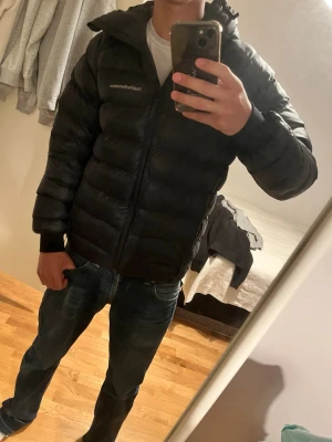 Svart pufferjacka från Peak Performance - Snygg svart pufferjacka från Peak Performance med huva och dragkedja framtill. Storlek S och är i riktigt fint skick, har kvitto och alla og lappar.