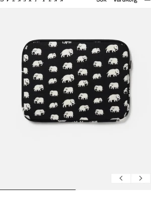 SVENSKT TENN datorfodral - Snyggt datorfodral från Svenskt Tenn i svart tyg med vitt elefantmönster. Fodralet har dragkedja och är fodrat på insidan. Perfekt för dig som vill ha ett unikt och lekfullt skydd till din laptop. Materialet är slitstark textil med klassiskt mönster.