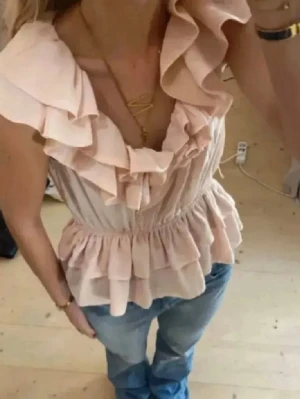 Trendig rosa volangtopp från hm💗 - Supersöt beige topp med volanger och v-ringning. Toppen har ärmlös design och dubbla volanglager nedtill som ger en romantisk och trendig look. Perfekt att styla med jeans eller kjol för en chic outfit. INTRESSEKOLL!💗💗💗