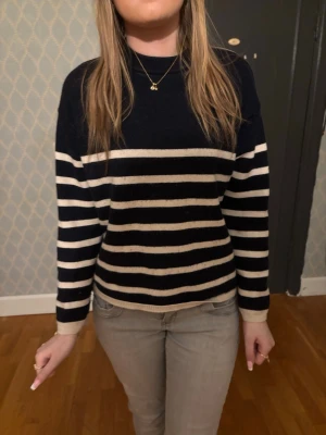 Svartvit randig tröja i mjukt material - Snygg svart tröja med vita horisontella ränder och rund hals. Tröjan har långa ärmar och en avslappnad passform. Perfekt för en chill och stilren look. Materialet känns mjukt och bekvämt mot huden.