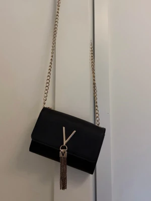 Svart axelväska från Valentino - Säljer nu min valentino väska som är i väldigt bra skick. Köptes på plick för ungefär ett år sedan och har tyvärr inte kommit till användning 💕