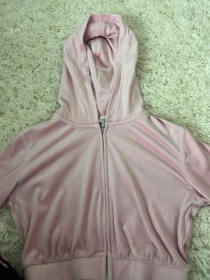 Ljusrosa hoodie från H&M Divided - Säljer en ljusrosa hoodie från H&M Divided i mjukt velourmaterial. Hoodien har dragkedja framtill, huva och bred mudd nedtill. Perfekt för en chill och avslappnad stil. Enkel och snygg design utan tryck eller mönster.