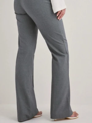 Grå kostymbyxor med utsvängda ben - Snygga grå kostymbyxor med utsvängda ben och klassisk passform. Perfekta för en stilren look och enkla att matcha med olika toppar. Byxorna har en rak siluett och är tillverkade i ett mjukt material som ger en bekväm känsla hela dagen. Dem är i nytt skick och från Nelly. Är i storlek L, men om man är över 172 cm så passar dem bättre. Små i storleken, för mer info kontakta gärna mig💕