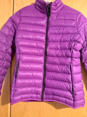 dunjacka från Everest - Säljer en snygg lila dunjacka från Everest. Jackan har två sidofickor med dragkedja och en mörklila insida. Perfekt när det är lite kyligt.  Storlek 36 för barn 