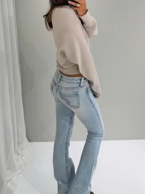 Ljusblå bootcut jeans från gina - Säljer ett par ljusblå bootcut jeans från gina 14+ med klassisk femficksmodell och snygga slitningar. Jeansen har låg midja och utsvängda ben, vilket ger en retrovibe. Tillverkade i mjuk denim med stretch för extra komfort.