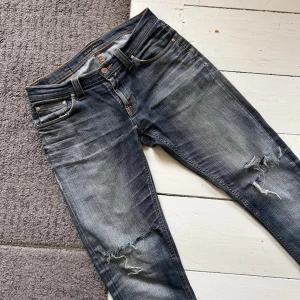 Gråa Nudie Jeans - Riktigt feta Nudie jeans. | W29 L32. | Nypris: 1699kr. | Jeansen har hål i skrevet men går att fixa snabbt och enkelt hos en skräddare. Finns även hål/slitningar på knäen men enligt mig är det snyggt. Står ej exakt vilken modell, men de sitter ungefär slim/lite relaxed. | Skriv vid minsta fundering. 