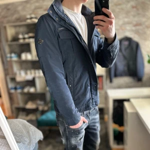 J.lindeberg bailey jacka - Bra skick, liten skada på magen som jag satte lagningslapp över. Passar dig som är mellan 175-185cm ungefär. Nypris ca 3000kr. Modellen är 185 cm, 75kg. Passar bra nu till våren! Skriv för mer information!🤝 