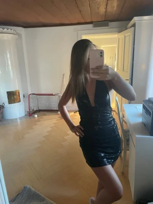 snygg fest klänning  - En snygg svart glittrig klänning från Bershka. Den har öppen rygg och ganska kort. Köpt i Spanien och har nu ingen användning för den. Helt oanvänd och lapp sitter kvar.❣️