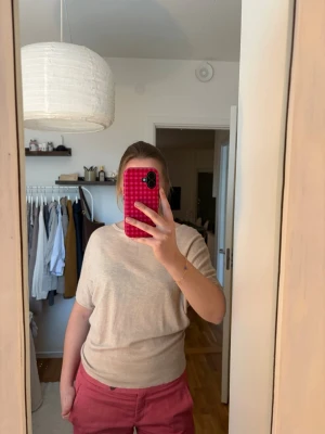 Trendig topp! - Stilren beige t-shirt med rund hals och något längre ärmar. T-shirten har en avslappnad passform och är tillverkad i mjuk bomull, sitter tightare längre ned vilket är supersnyggt 