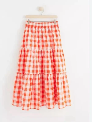 Rutig långkjol i orange och vitt från Lindex storlek S  - Superfin långkjol med volanger och rutigt mönster i orange och vitt. Kjolen har resår i midjan och är tillverkad i ett lätt och luftigt material, perfekt för varmare dagar. Snygg att styla med en enkel topp eller stickad tröja.