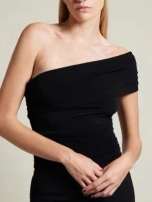 Svart offshoulder topp - Trendig svart offshoulder topp med en axel och rynkade detaljer. Perfekt för dig som vill ha en stilren och modern look. Toppens material känns mjukt och följsamt mot huden. .