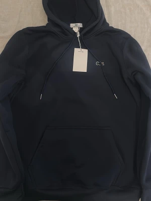 Lacoste  - En fin mörkblå Lacoste tröja 