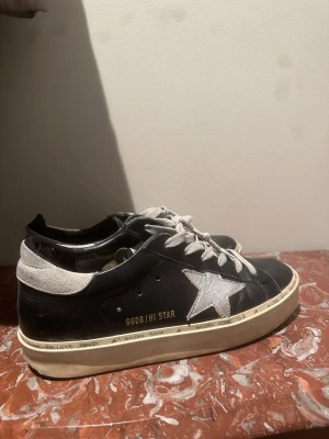 Svarta Golden Goose Hi Star sneakers - Golden Goose Hi Star sneakers i svart läder med vit stjärndetalj på sidan och vita skosnören. Intressekoll!