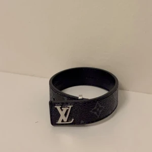 Svart armband - Snyggt svart armband  i präglat läder med det klassisk och en silverfärgad spänne. Perfekt accessoar för dig som gillar exklusiv och stilren design.