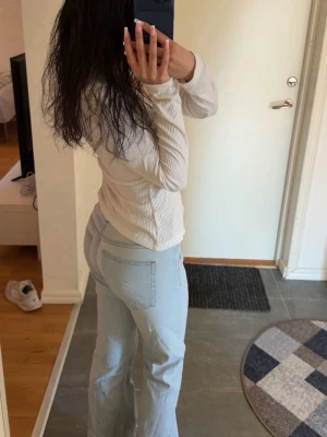 Ljusblå bootcut jeans - Säljer ett par ljusblå bootcut jeans med klassiska femficksdetaljer och snygga sömmar. Jeansen har en hög midja och är tillverkade i denim med stretch för skön passform. Perfekta för dig som gillar en avslappnad och trendig look.