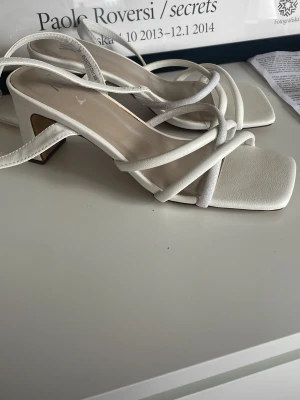 Vita trendiga sandaler med klack - Vita låga klackar från din sko. Helt nya och helt oanvända, tyvärr för stora för mig. Jätte bekväma och perfekta sommar skon. Nypris:600kr