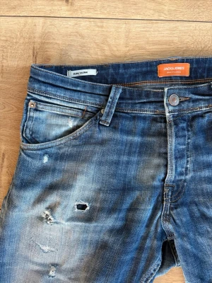 Jack&Jones jeans  - Seljer nu dessa feta Jack&Jones jeans de de inte kommer till användning längre. Jeansen har feta slitningar och snygg fade. Slim fitt model på jeansen i storlek 32/32. Modellen på bilden är 187cm lång och väger 70kg. Tveka inte på att kontakta vid fundering. Pris kan gå ner vid snabb affär⚜️🙌🔥
