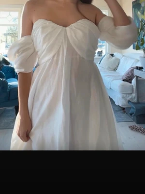 By Malina vit offshoulder kortklänning - Superfin vit kortklänning med offshoulder och puffiga ärmar. Perfekt för studenten.💕