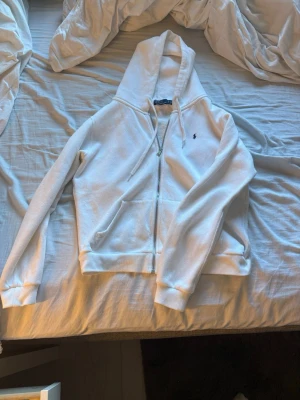 Vit hoodie från Ralph Lauren - Snygg vit hoodie från Ralph Lauren. Den är aldrig använd och i nytt skick.   Pris går att diskutera. Passar killar också fast passar som xs då.