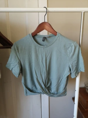 Cool topp  - Säljer en ljusgrön croppad topp från H&M Divided. Toppen har en fin detalj framtill. Är st M men den passar bättre på S eller till och med xs. Säljes pga garderobs rensning 