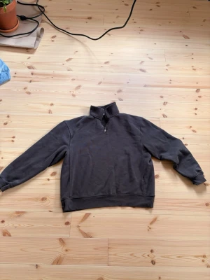 Mörkgrå halvzip sweatshirt från Zara - Säljer en mörkgrå sweatshirt från Zara i storlek XL. Tröjan har halv dragkedja vid halsen, ribbade muddar och är tillverkad i mjukt bomullsmaterial. Perfekt för en chill och avslappnad stil.