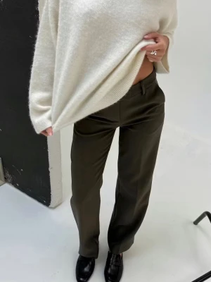 Olivgröna kostymbyxor med raka ben - Snygga olivgröna kostymbyxor med raka ben och medelhög midja. Perfekta för en stilren look och lätta att matcha med olika toppar. Nypris: 499