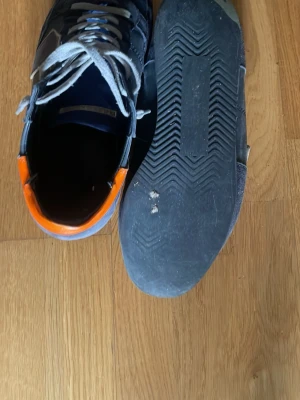 Philippe model - Snygga blå sneakers från Philippe model perfekta till sommaren. Som får en snygg tusch med det orange där bak. Kan gå ner i pris!