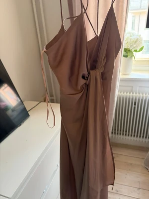Beige satinklännig  - Säljer en lång satinklänning i färg brun/beige. Mycket fint skick