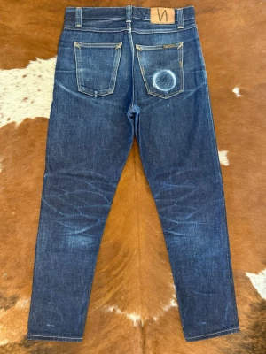 NudieJeans SteadyEddie ii DryAceSelvage - Tjena! Säljer dessa riktigt snygga nudie jeans i modellen SteadyEddie II: Modellen är i deras mest exklusiva material ACE Selvage som kostar 3500kr nya: Storlek W29/L32 men passar som W30/L30 och sitter bra på någon som är cirka 175cm/70kg: Hör av dig vid funderingar!🙌