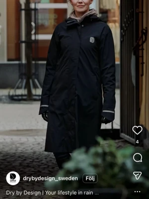 Svart lång regnjacka Dry by Design - Womens - Dry by Design regnkappa – ny och stilren  Säljer helt nya regnkappor från svenska Dry by Design. En snygg och funktionell regnkappa med lång modell, perfekt för promenader, pendling och cykling. Vind- och vattentät med tejpade sömmar, justerbar huva och diskreta reflexdetaljer.  Jag har:  * 2 st Large (42-44) * 1 st Medium (38-40)  Nypris var 1900 kr. Hör gärna av dig om du vill veta mer eller komma och prova! 