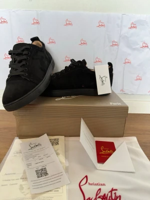 Svarta sneakers från Christian Louboutin - Säljer ett par svarta sneakers från Christian Louboutin i mocka med klassisk låg profil och svarta skosnören. Skorna har diskret logga och den ikoniska röda sulan. Kommer med originalkartong, dustbag och äkthetskort.