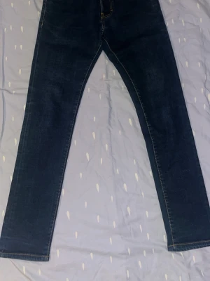 Mörkblå raka jeans - Snygga mörkblå jeans med raka ben och klassisk femficksdesign. Jeansen har kontrastsömmar och är tillverkade i ett slitstarkt denimtyg. Passar perfekt till en avslappnad stil och är ett måste i garderoben.