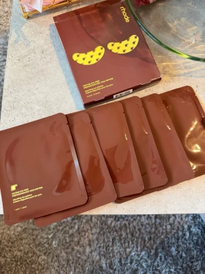 Rhode Peptide Eye Prep ögonmasker - Säljer Rhode Peptide Eye Prep depuffing eye patches. Förpackningen innehåller 6 par ögonmasker i individuella bruna påsar. Perfekta för att fräscha upp huden under ögonen. Snygg brun och gul design på förpackningen.
